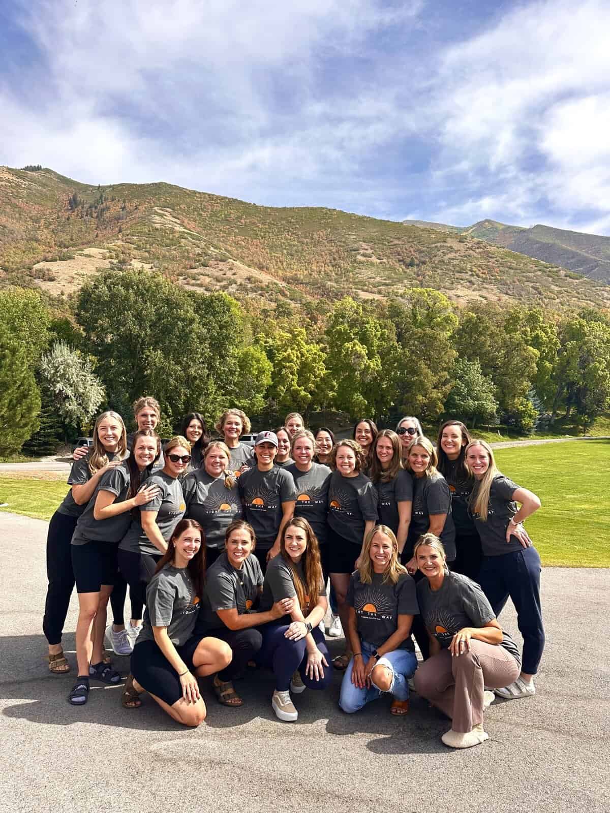 A group of girls posing and smiling in front of a mountain