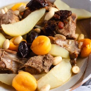 A bowl of Lham Lahlou with tender meat, dried fruits, almonds, and pears.