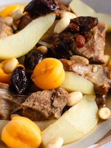 A bowl of Lham Lahlou with tender meat, dried fruits, almonds, and pears.