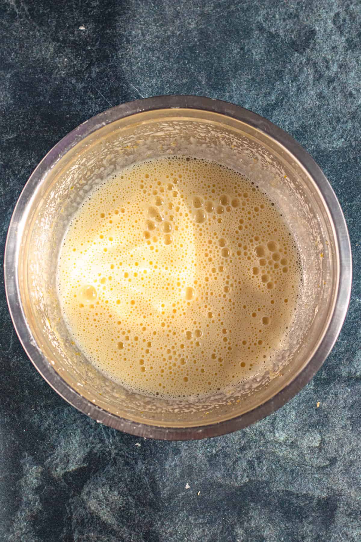 Mixing bowl with eggs, sugar and vanilla whipped together to a light pale color. 
