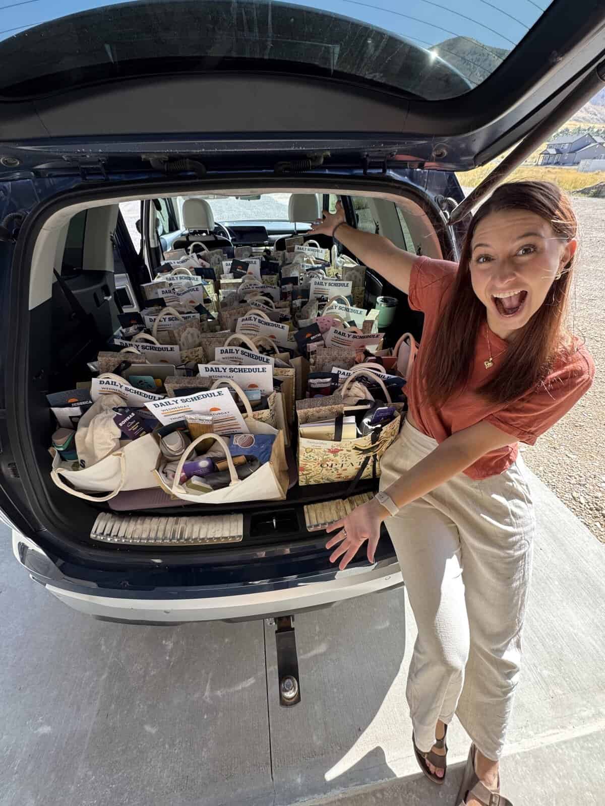 A car trunk full of swag bags with an excited girl at the front