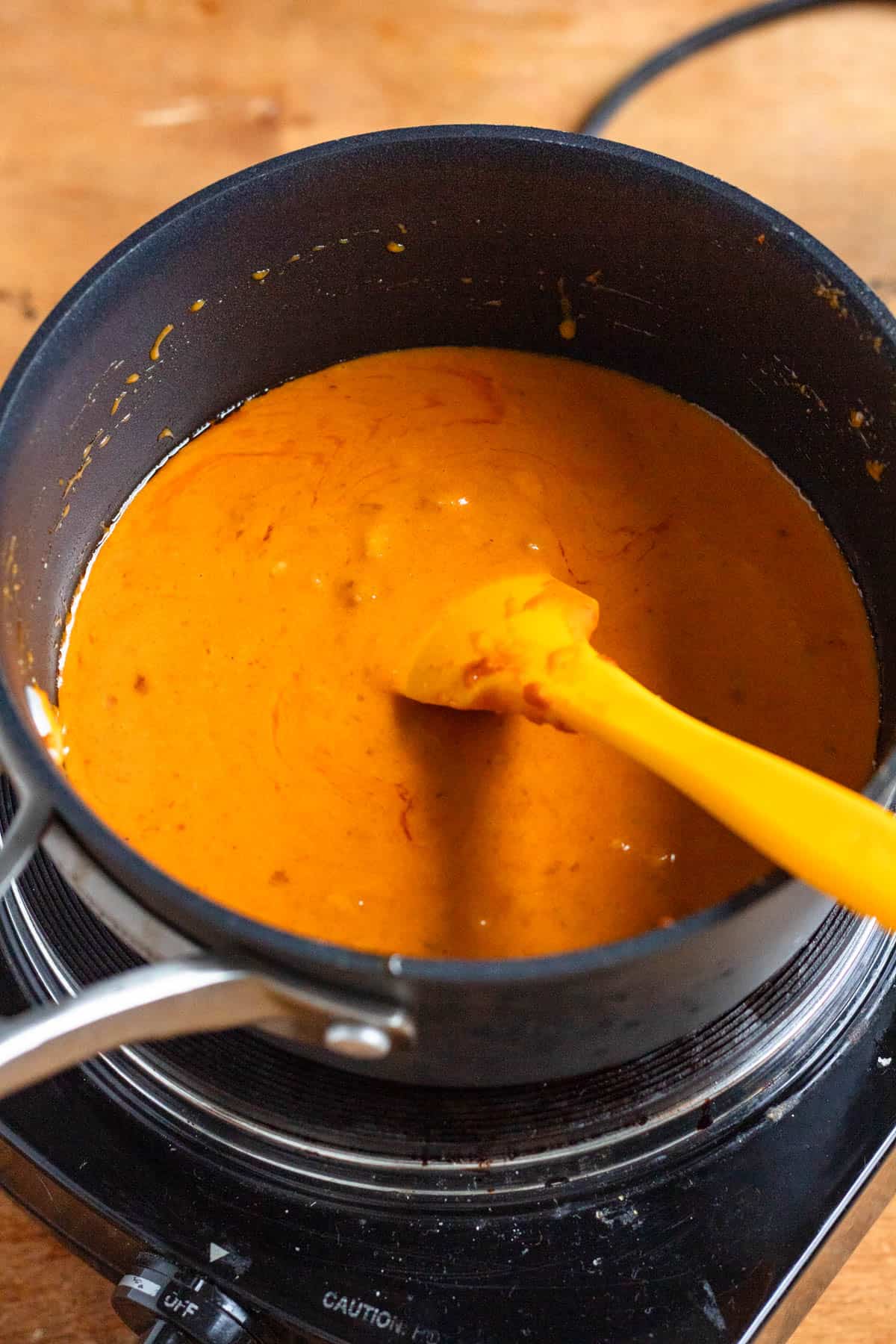 Coconut milk cooks with peanuts, palm sugar, and tamarind paste in the pot.