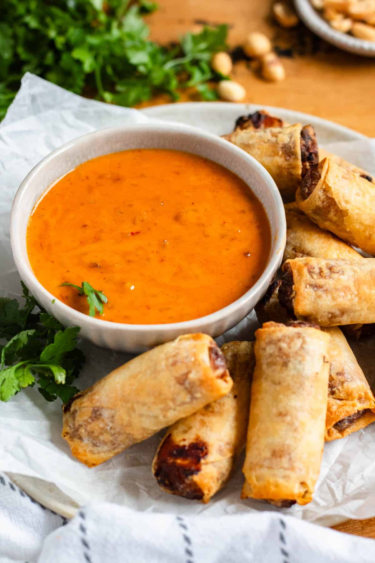 A bowl of creamy Thai peanut sauce served with crispy spring rolls.