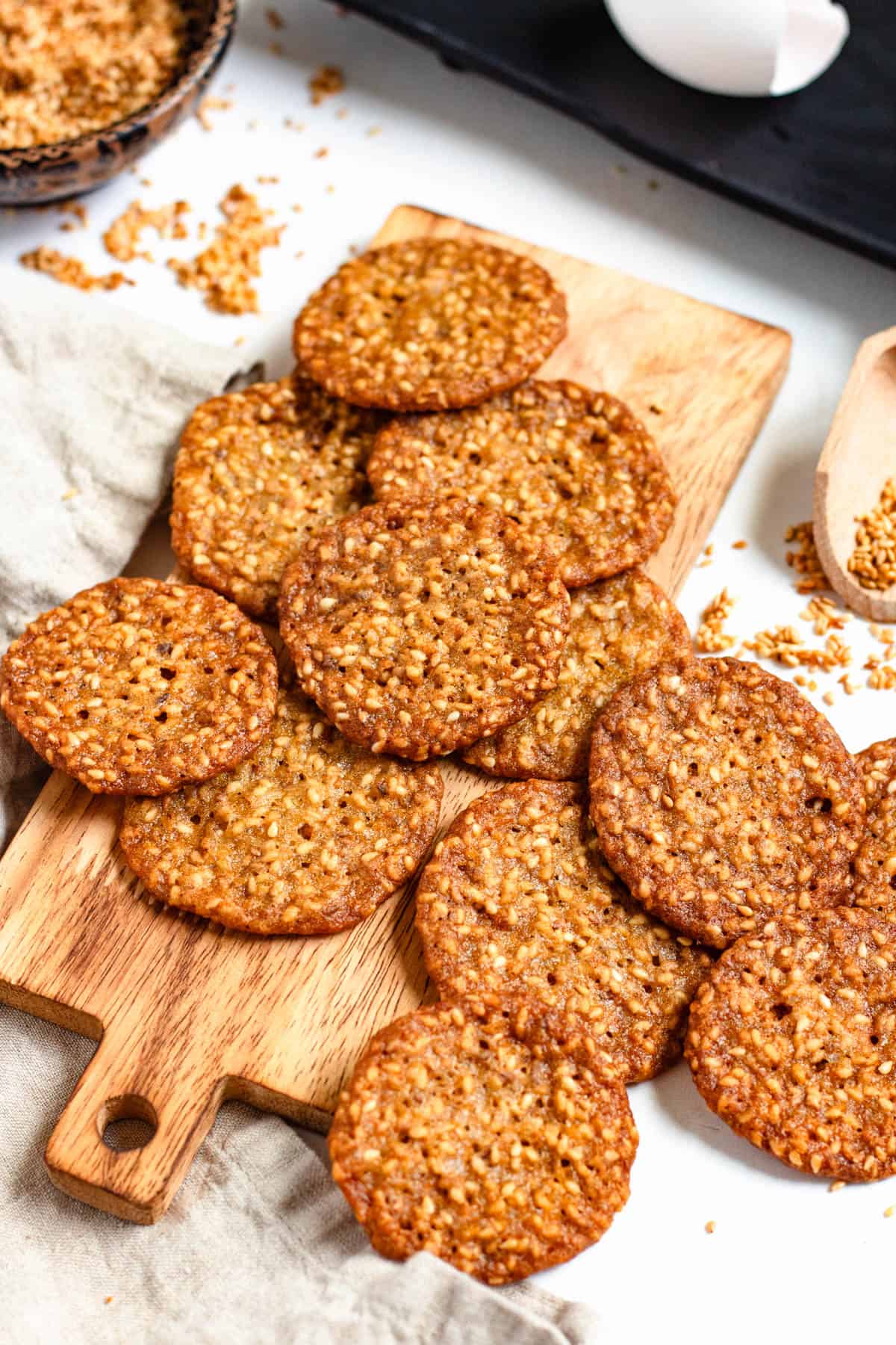 Freshly baked Benne Wafers arranged on a wooden board.