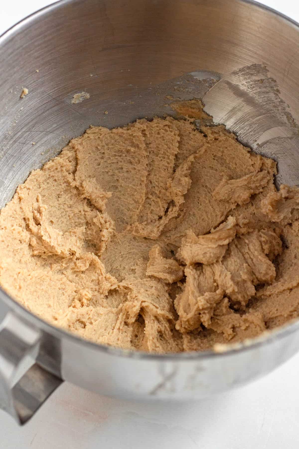 Unsalted butter and brown sugar being mixed together in a stand mixer.