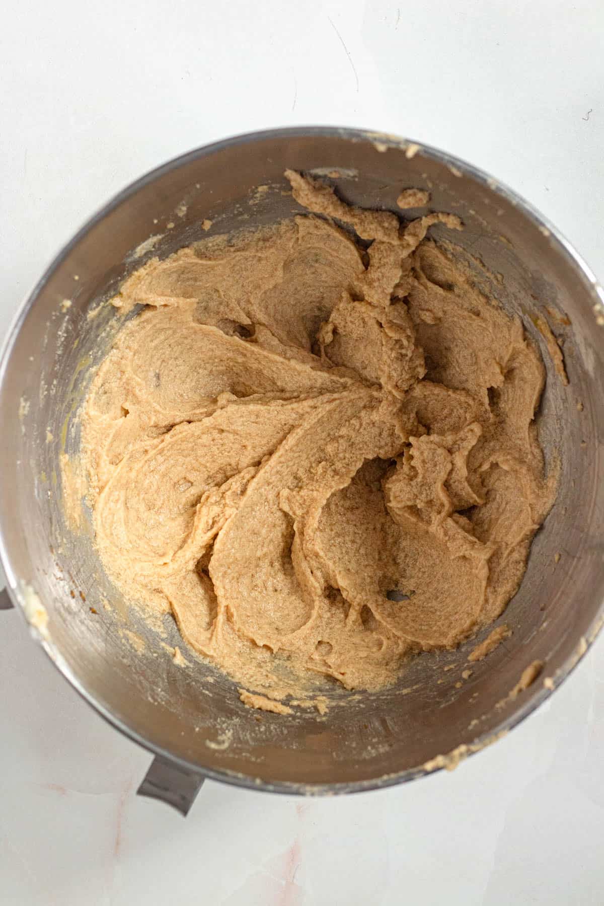 Dry ingredients, egg, and vanilla extract added to the butter and sugar mixture in a stand mixer bowl.