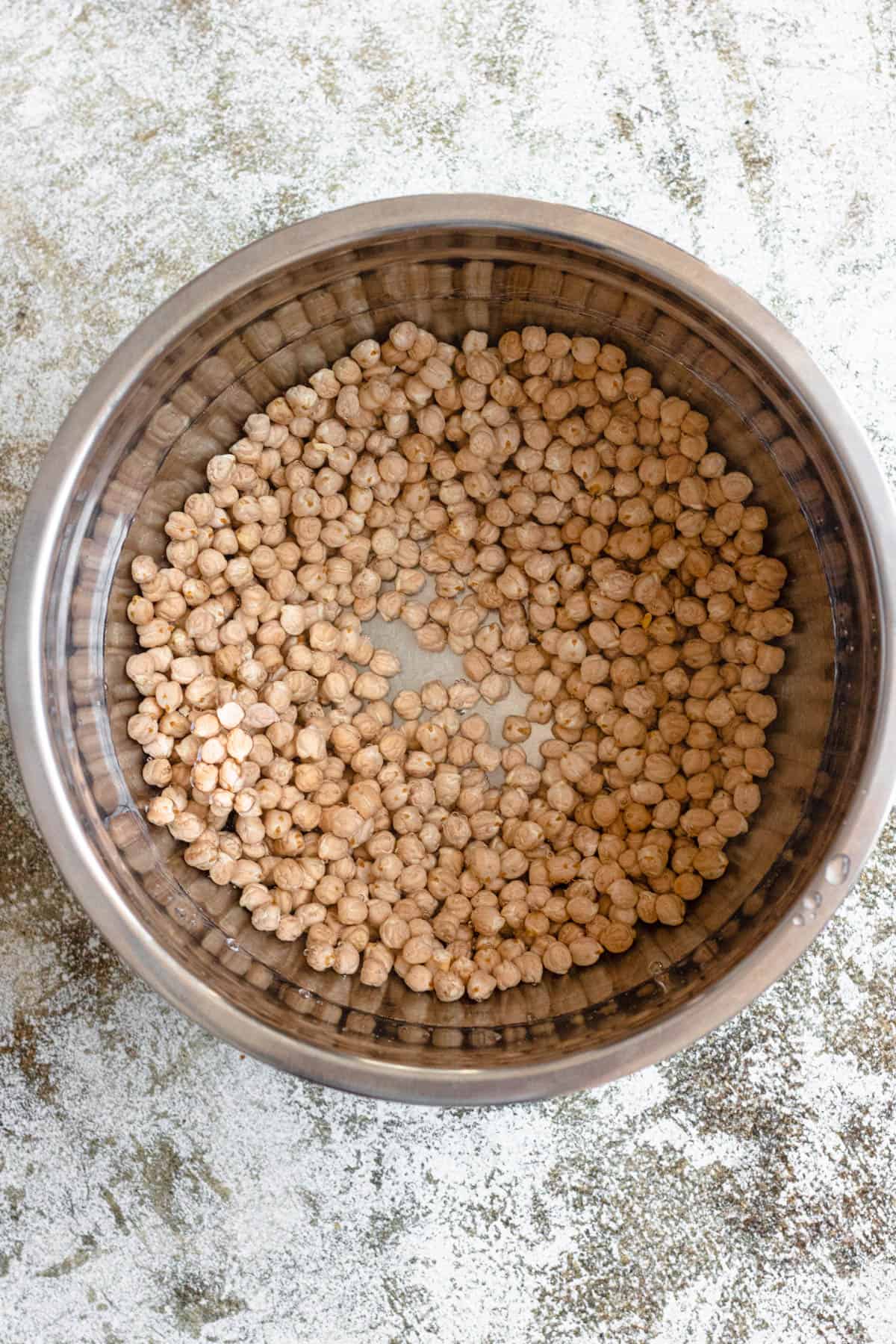 Dried chickpeas are being poured into a bowl.
