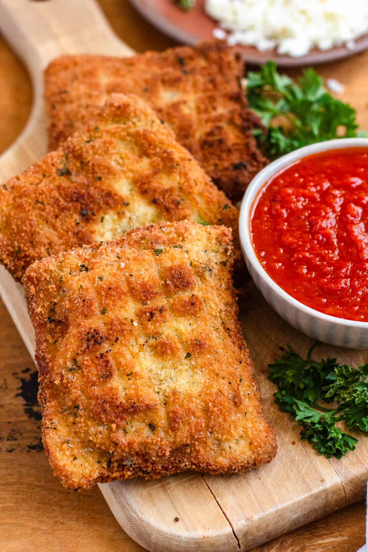Golden, crispy Mozzarella in Carrozza served with a bowl of marinara sauce