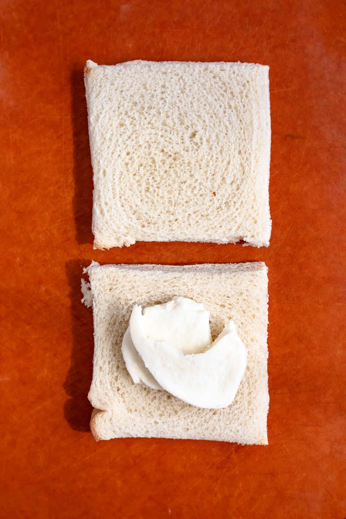 One slice of bread topped with two pieces of mozzarella cheese.