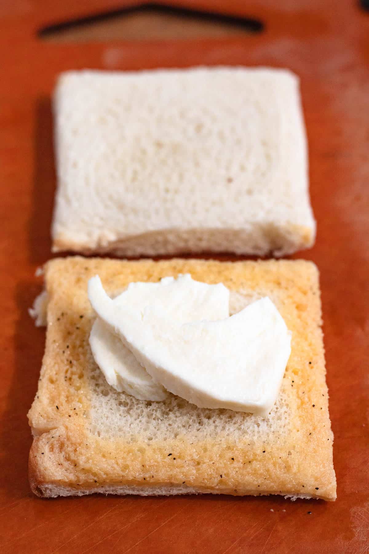 Beaten egg brushed along the edges of the bread topped with mozzarella.