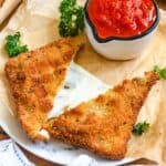 Golden, crispy Mozzarella in Carrozza served with a bowl of marinara sauce.