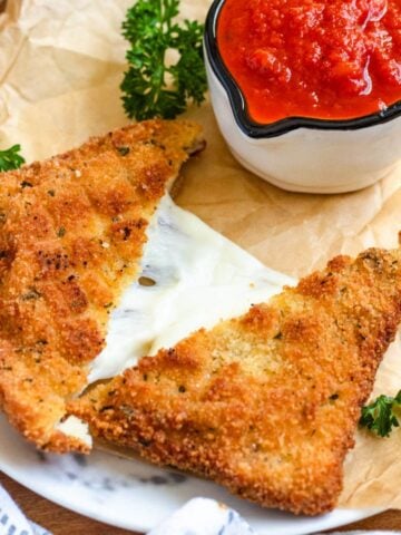 Golden, crispy Mozzarella in Carrozza served with a bowl of marinara sauce.