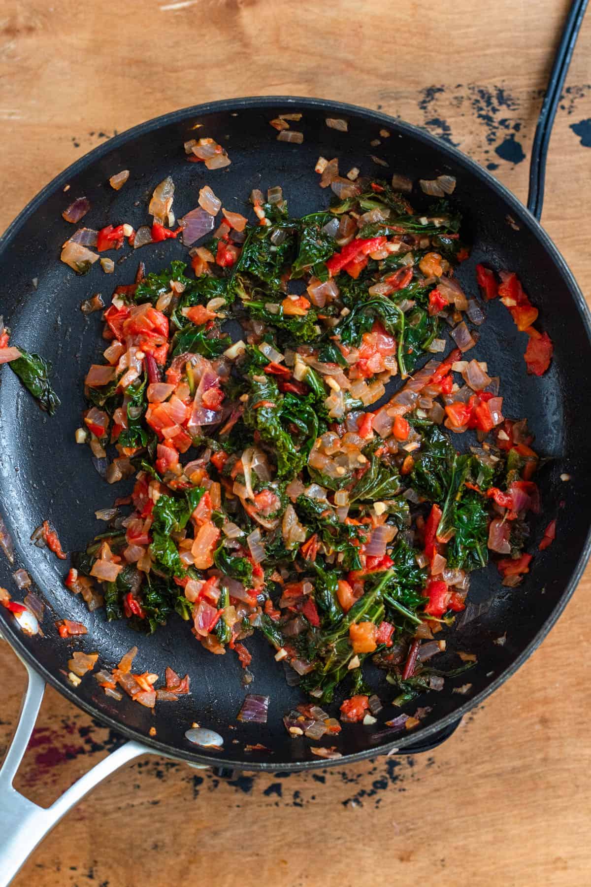 Greens cooking in a covered pan with water until tender.