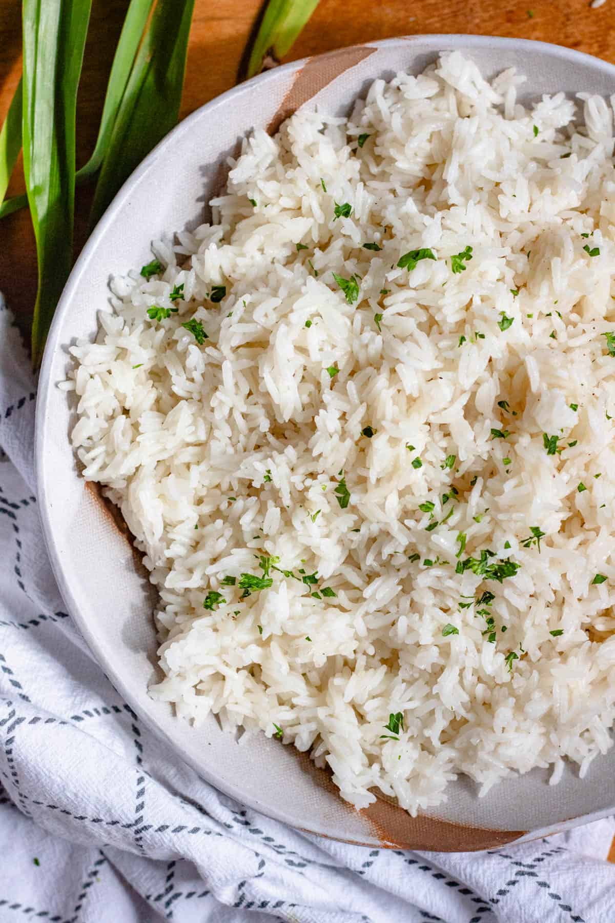 Close-up image of coconut rice garnished with chopped parsley.