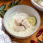 A bowl of Garudhiya, a Maldivian fish soup served with rice, red onions, and lime.