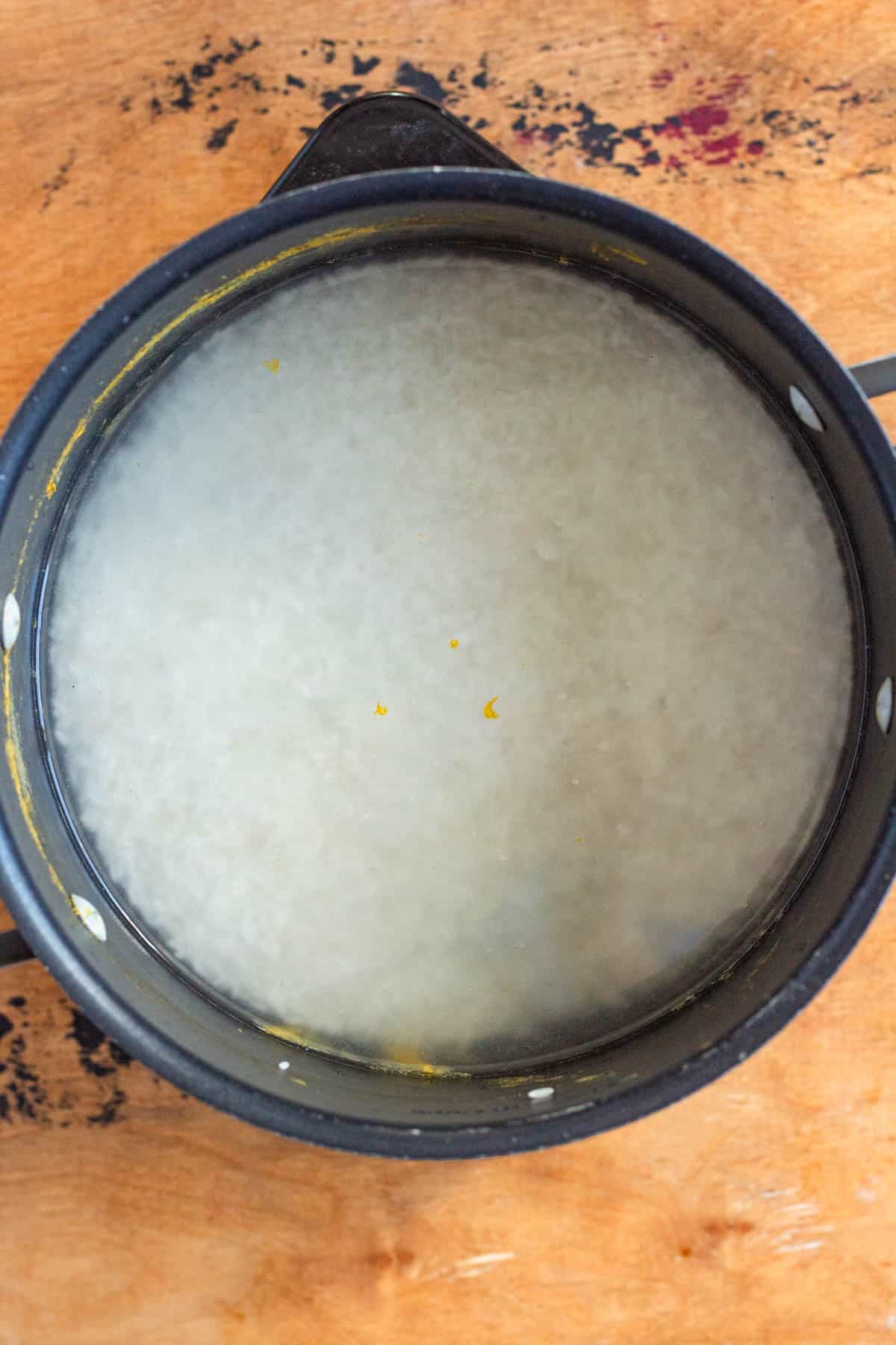 A pot filled with rice and water, ready to cook.