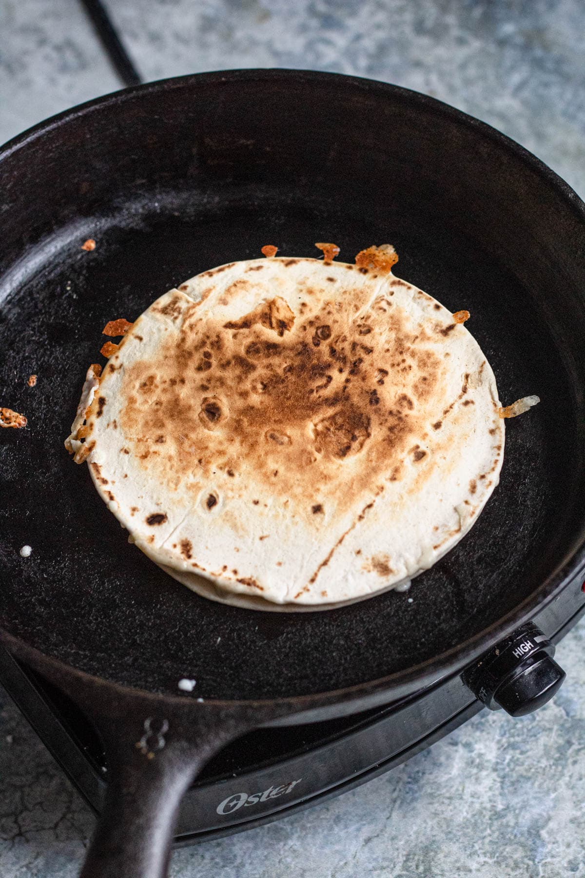 A sincronizada heating up in a cast iron skillet.