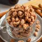 Candied peanuts coated in a crunchy sugar crust in a glass cup.