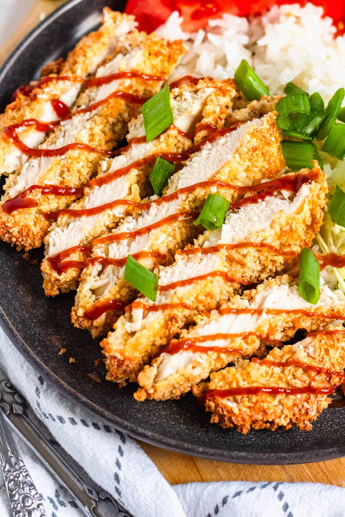 Close-up image of crispy sliced Air Fryer Chicken Katsu drizzled with sauce.