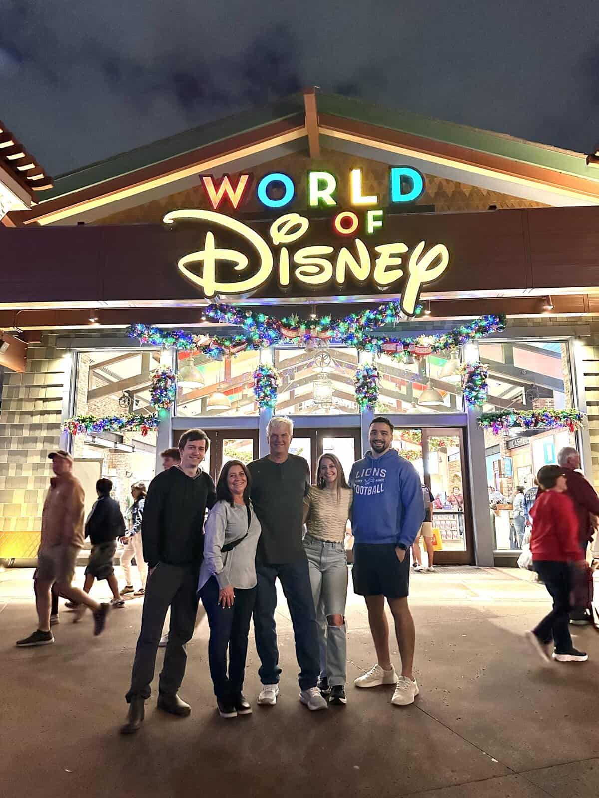 A family standing in front of a store that says world of disney 