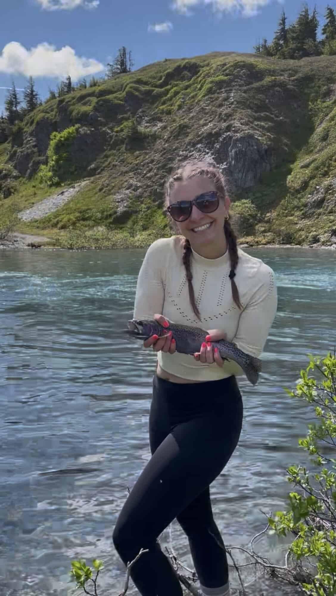 A girl smiling and holding a fish