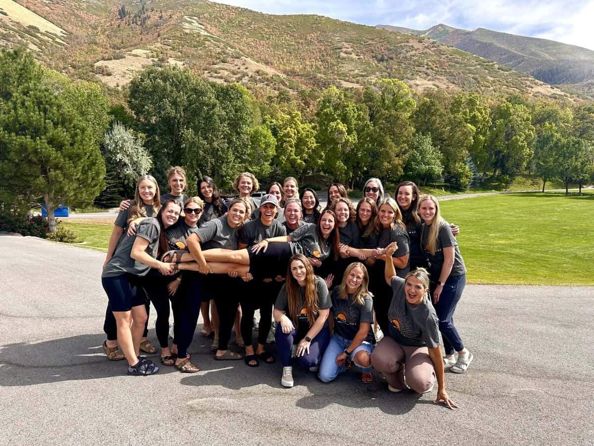A group smiling and holding a girl 
