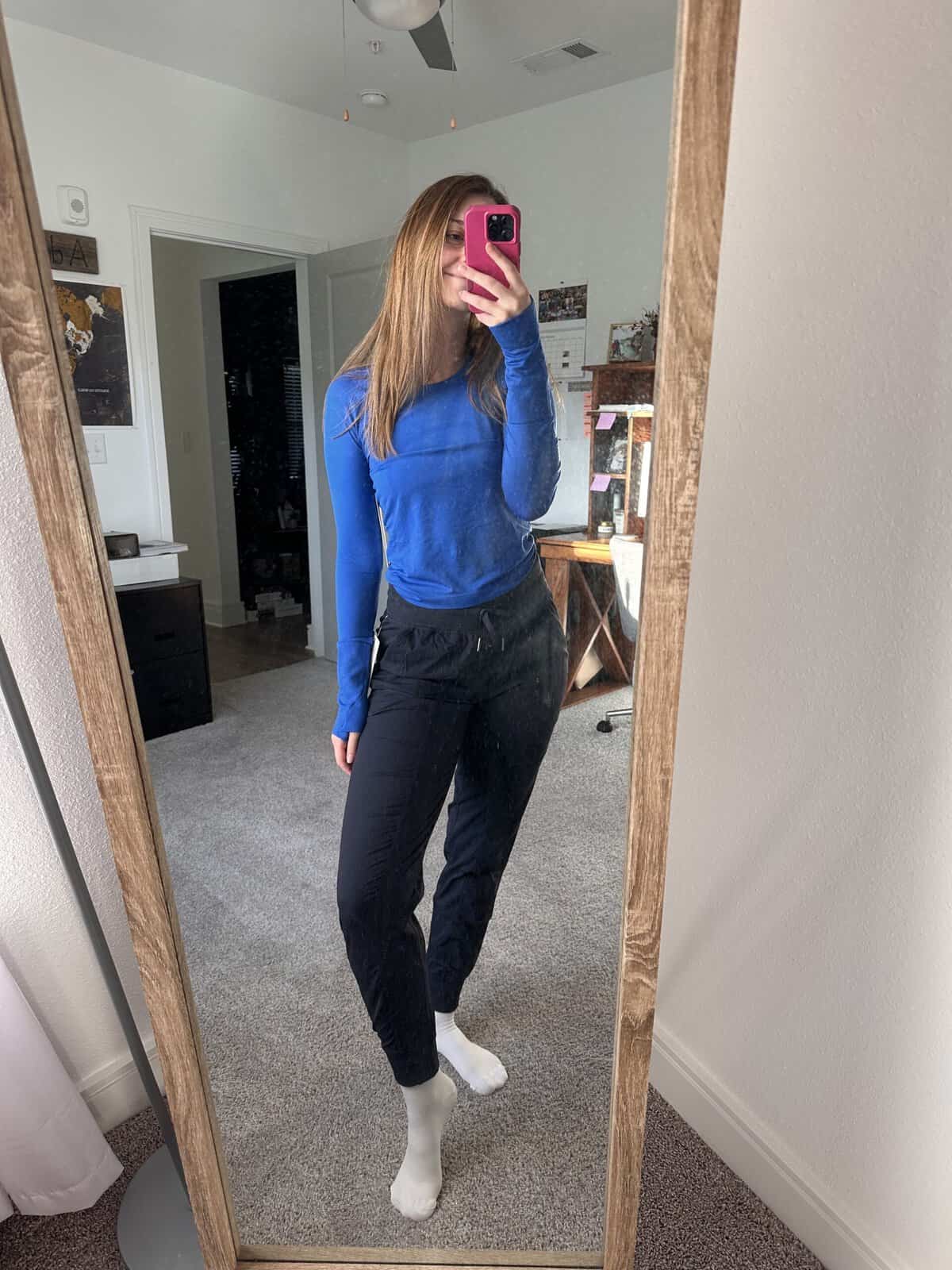 A mirror selfie of a girl in a blue shirt 