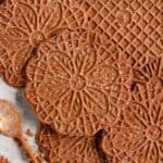 Chocolate Pizzelles lightly dusted with powdered sugar.