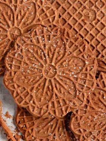 Chocolate Pizzelles lightly dusted with powdered sugar.