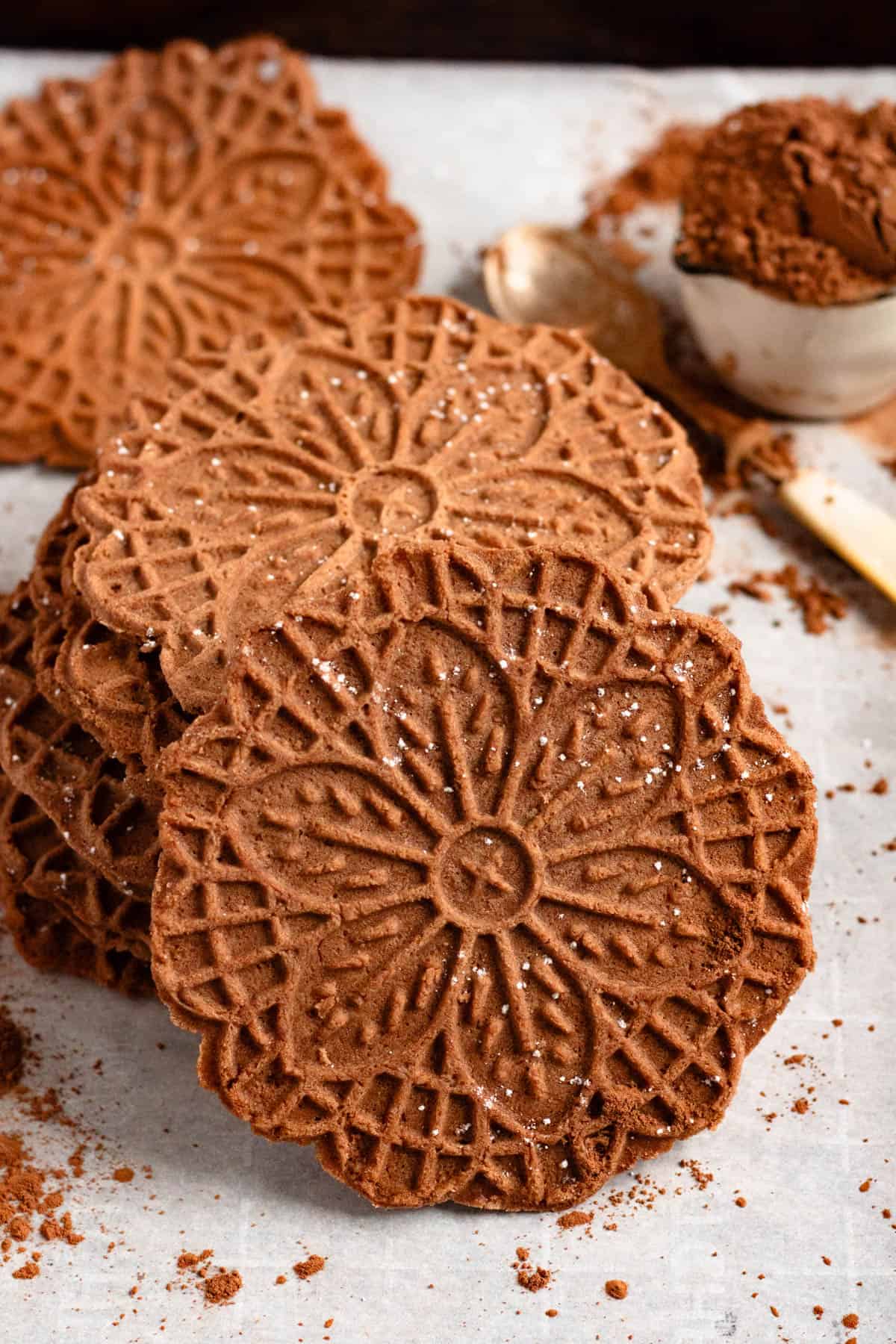 Stack Chocolate Pizzelle lightly dusted with powdered sugar.