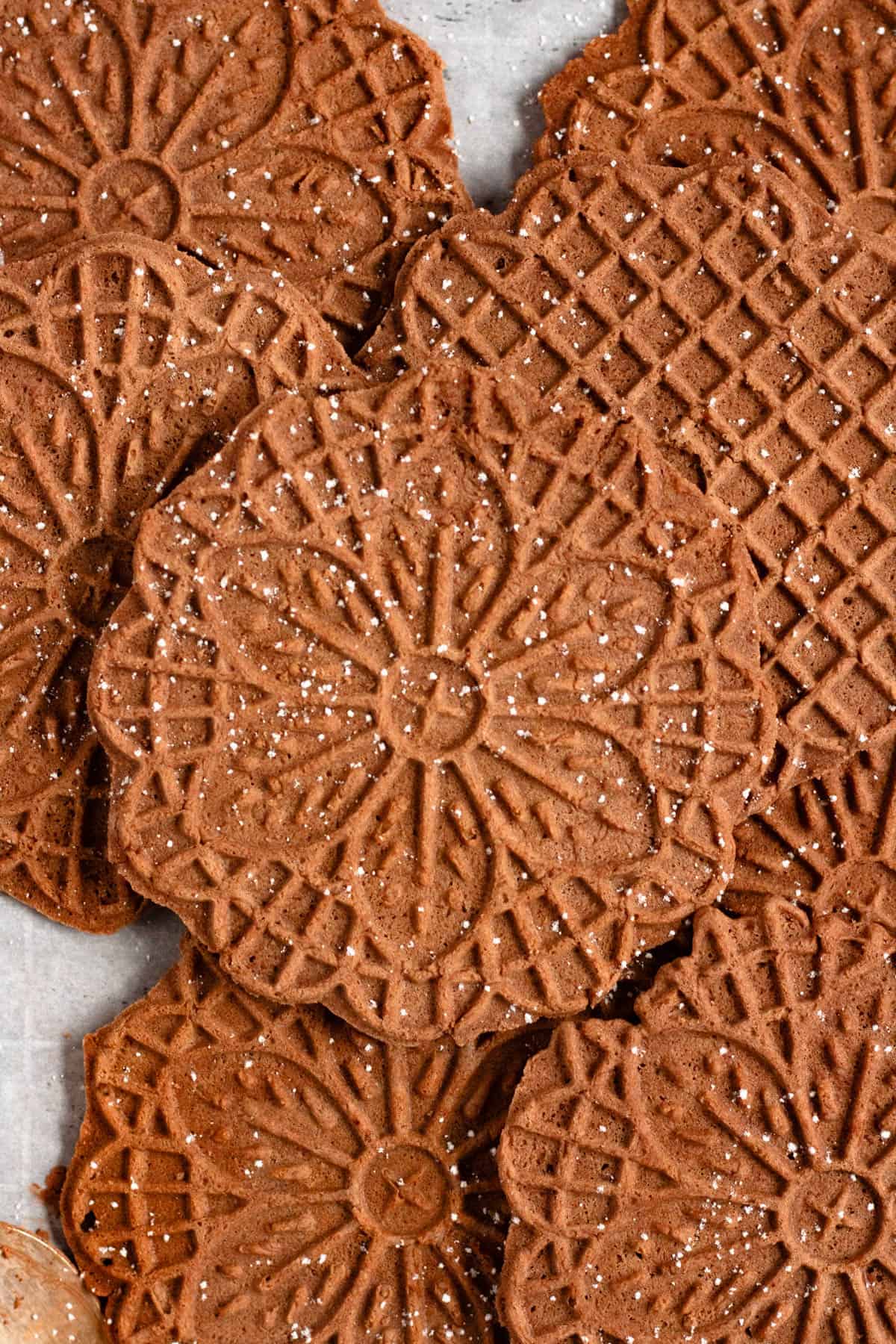 Chocolate Pizzelles lightly dusted with powdered sugar.