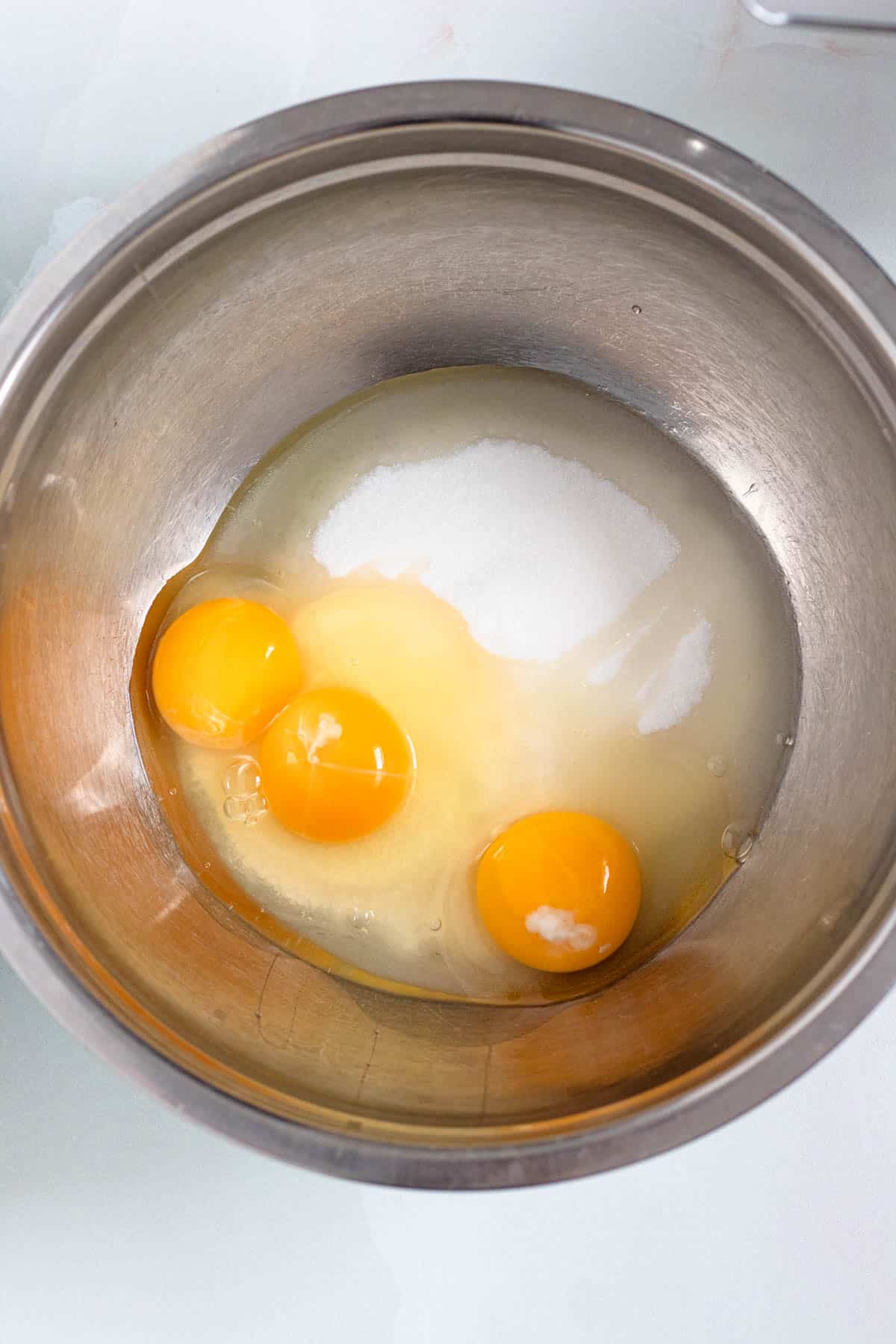 Eggs and sugar being whisked together in a mixing bowl.
