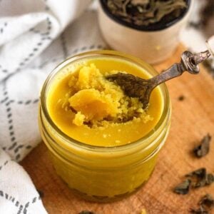 A jar of golden Niter Kibbeh with a spoon scooping it.