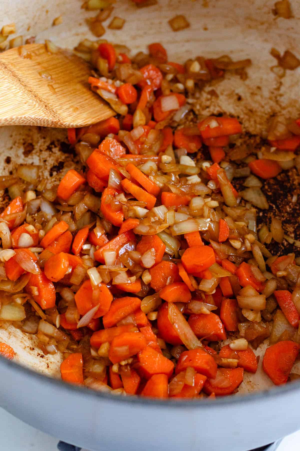 Carrots, onion, and garlic sautéing in the pot until softened, with tomato paste.