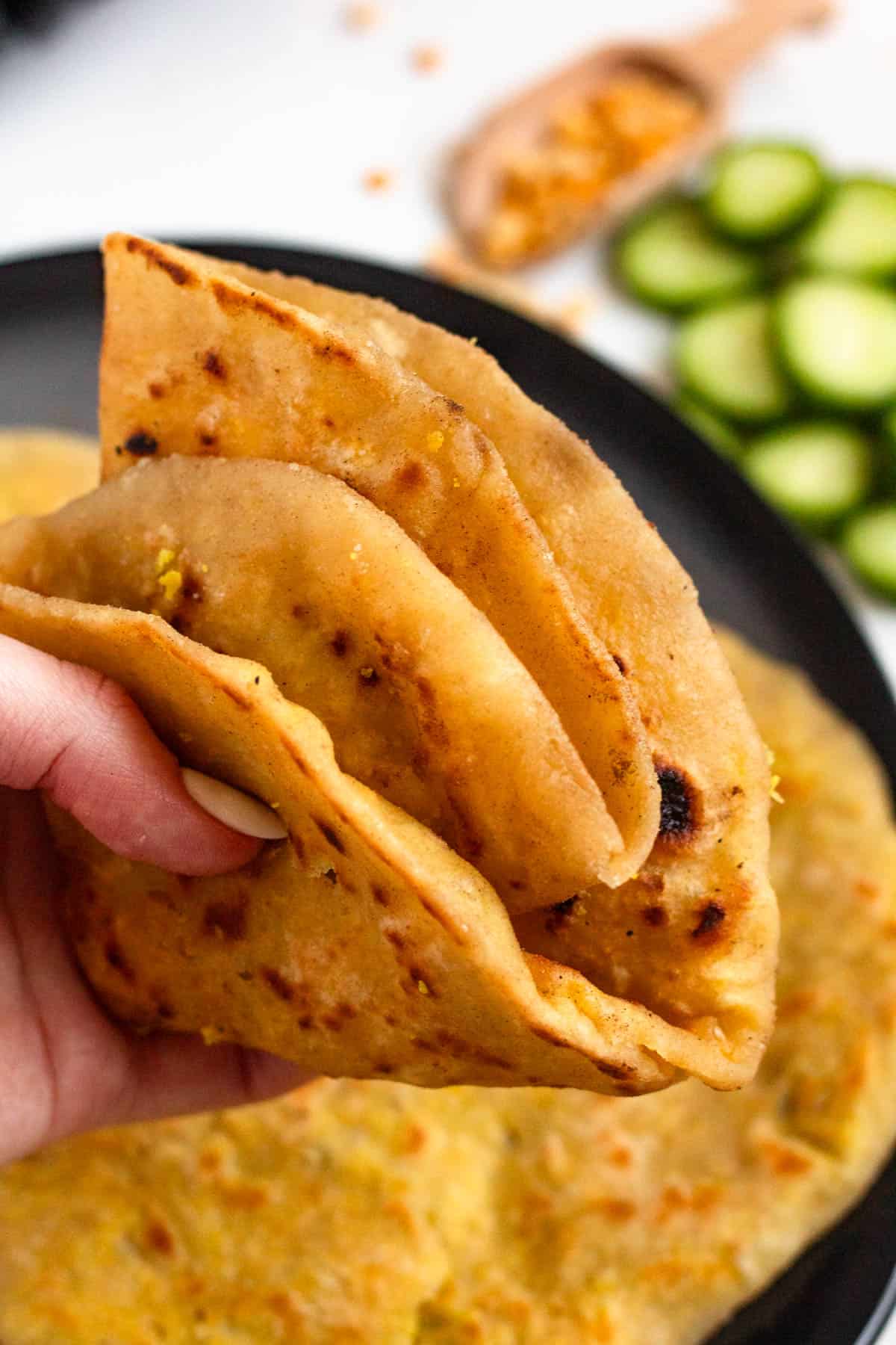 Hand holding a folded Dhal Puri.