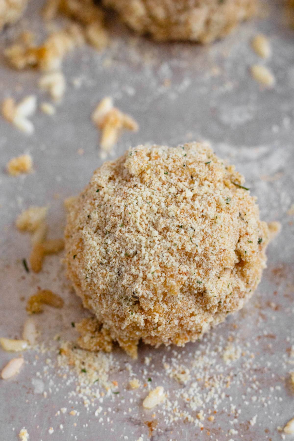 Rice ball coated in breadcrumbs, ready to be cooked.