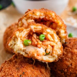 Crispy golden Arancini with green peas and mozzarella filing.