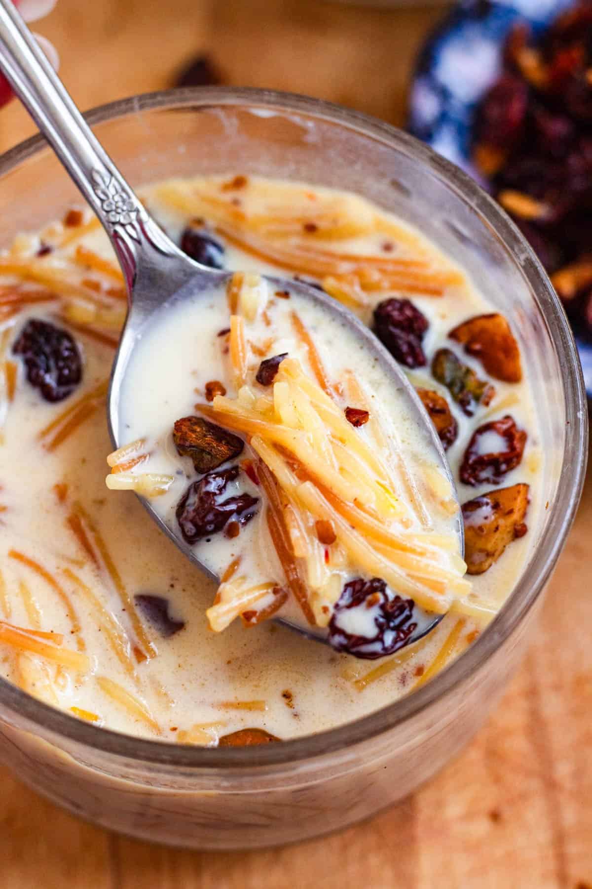 Spoonful of creamy sweet vermicelli porridge with raisins and crunchy nuts.
