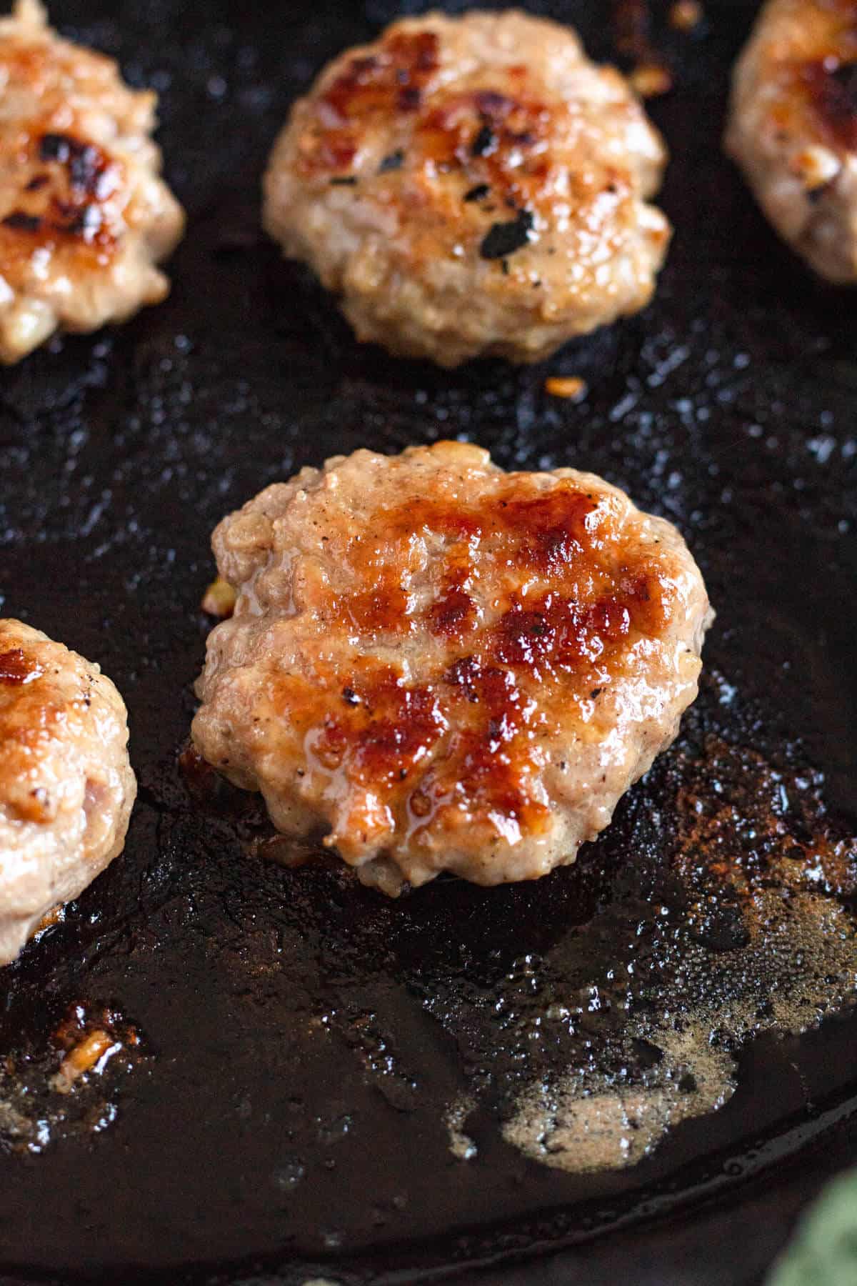 Juicy pork patties grilling until golden brown and caramelized.