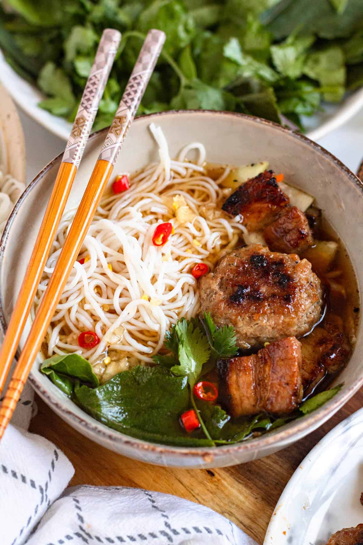 Bún Chả served with vermicelli noodles, grilled pork, herbs, and dipping sauce.