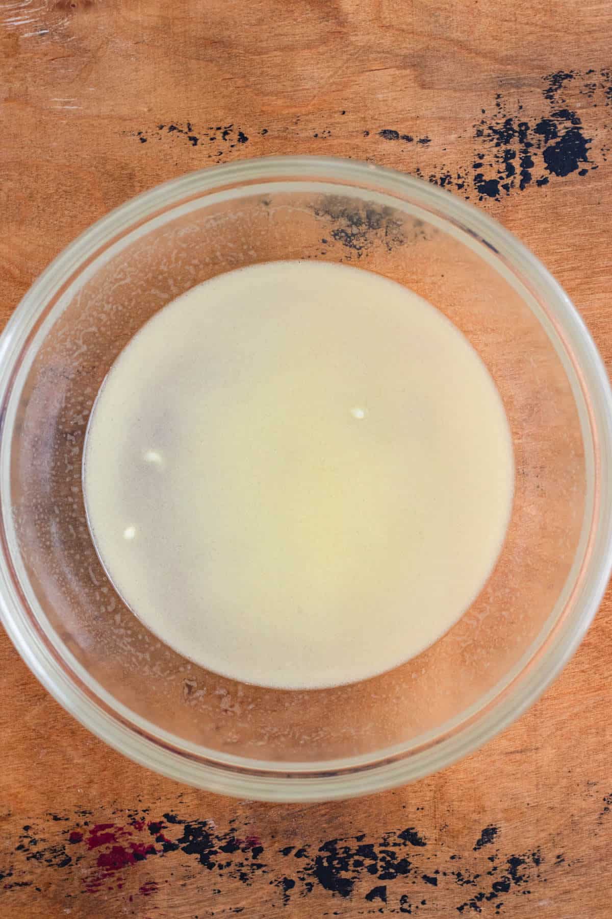 Boiling water, melted butter, and salt mixed in a glass bowl.