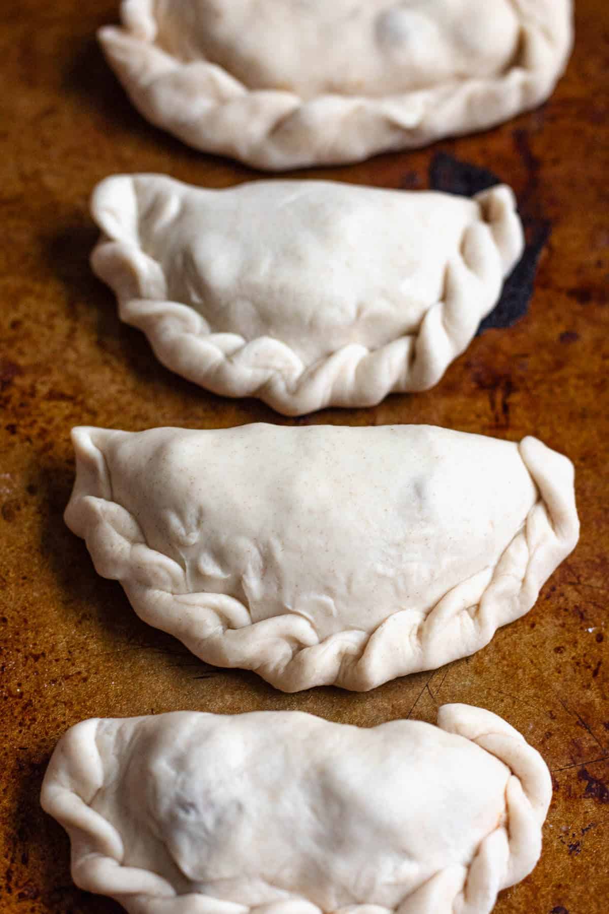 Argentinian empanada dough folded and sealed with decorative edges.