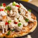 Close-up of delicious Chicken Kelaguen on titiyas with fresh coconut, onions, and spicy red chilies.