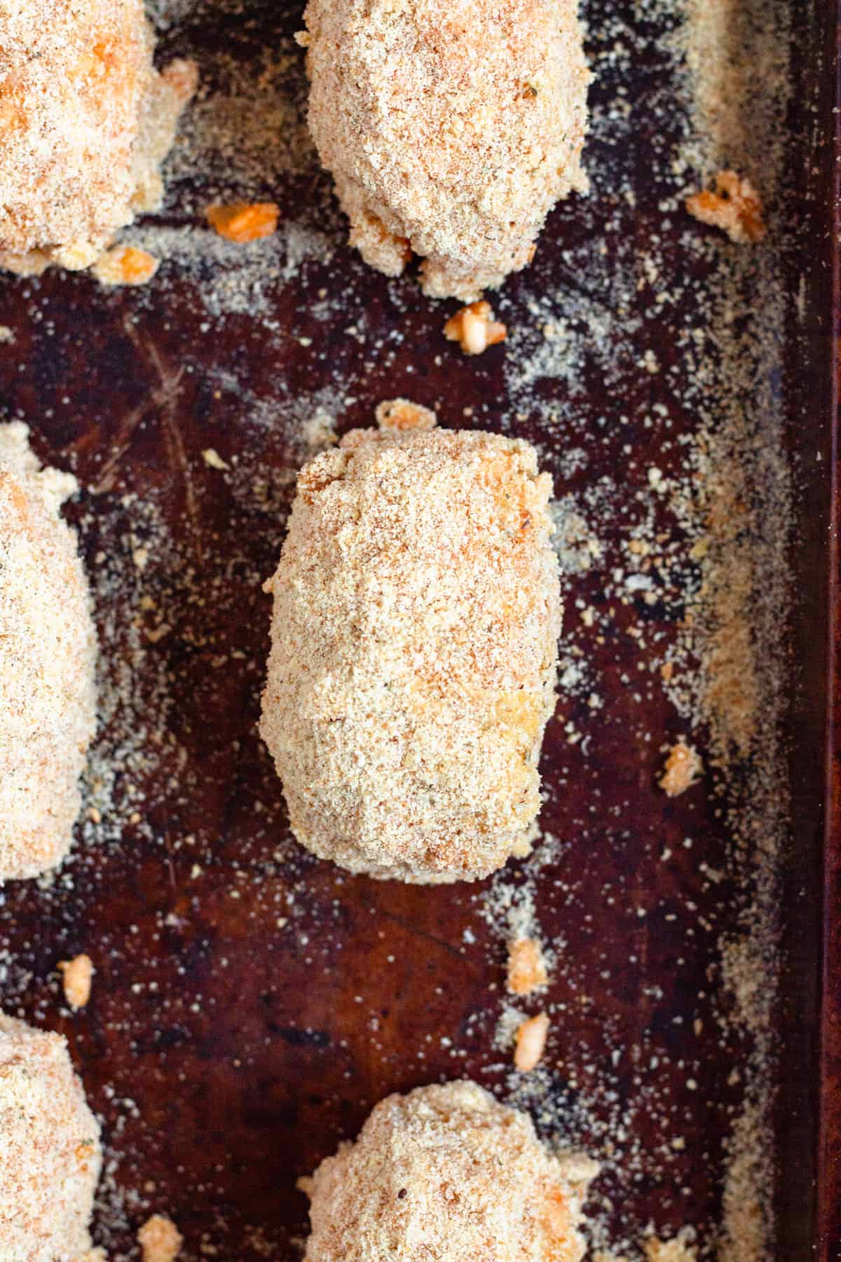 Breadcrumb-coated supplì arranged on a baking sheet.