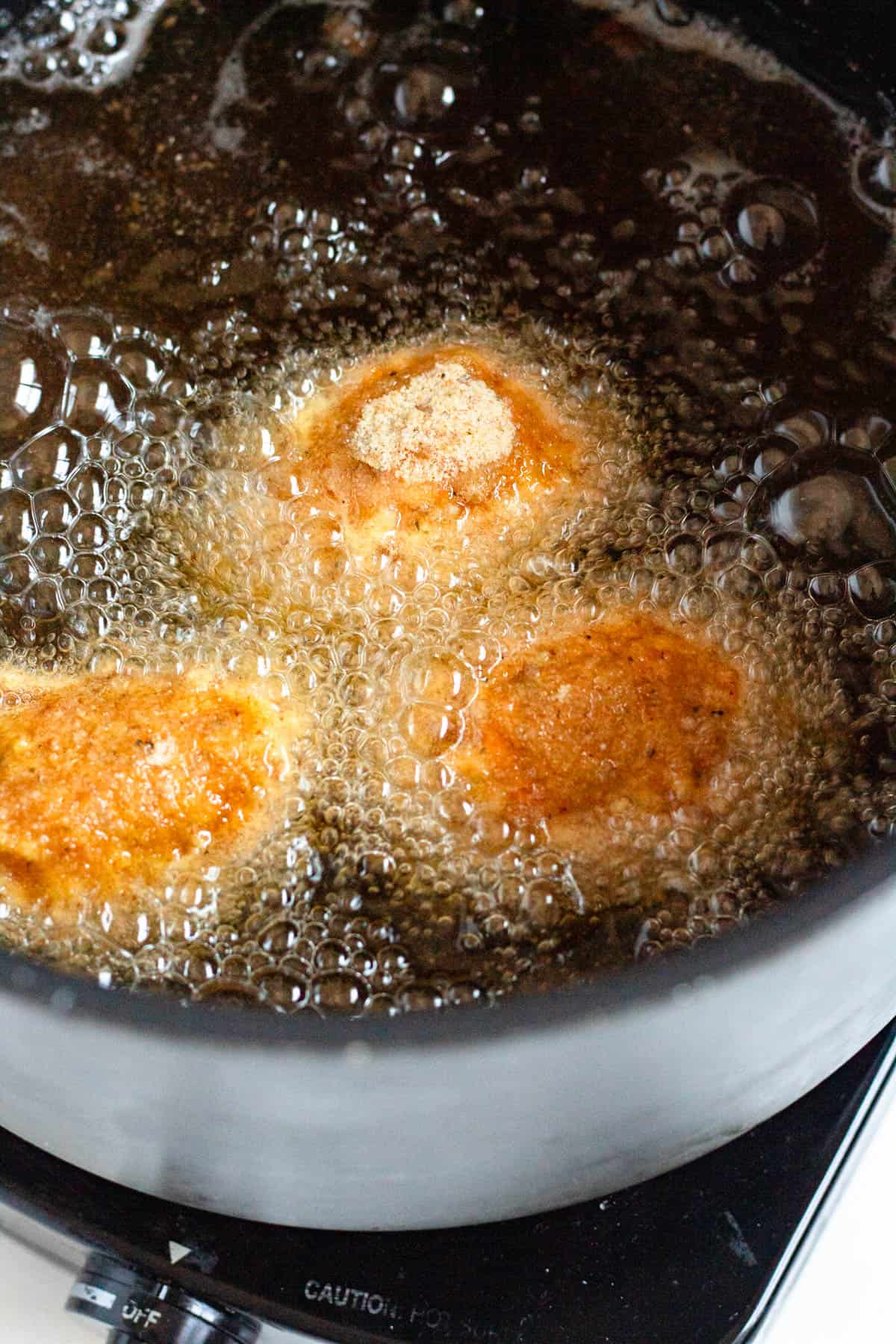 Supplì frying in hot oil until golden brown.