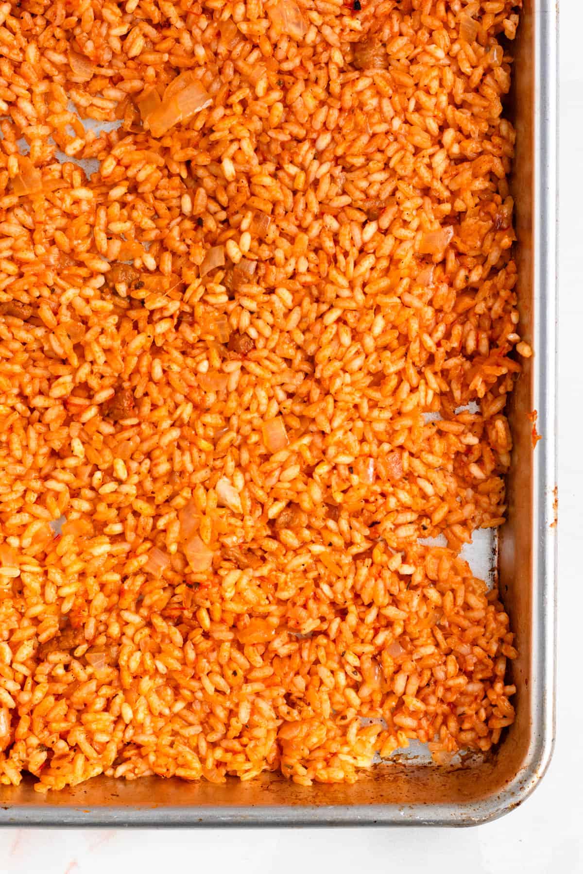 Cooked supplì rice spread on a baking sheet to cool.