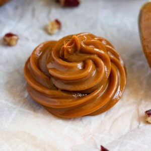 Thick homemade dulce de leche piped into a glossy caramel swirl.