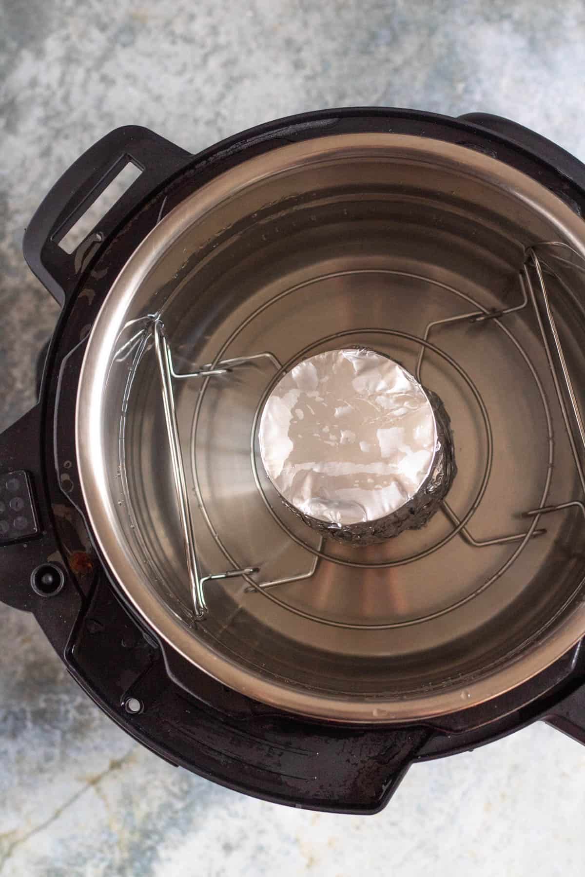 Foil-wrapped can of sweetened condensed milk inside the Instant Pot.