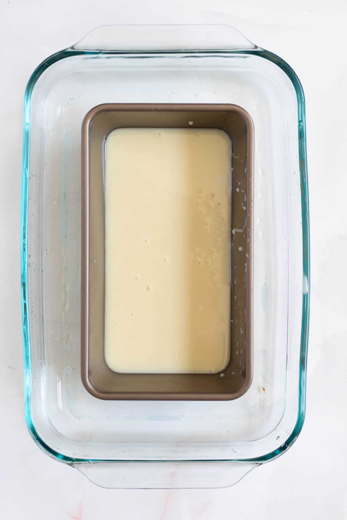 Sweetened condensed milk in a water bath for oven dulce de leche.