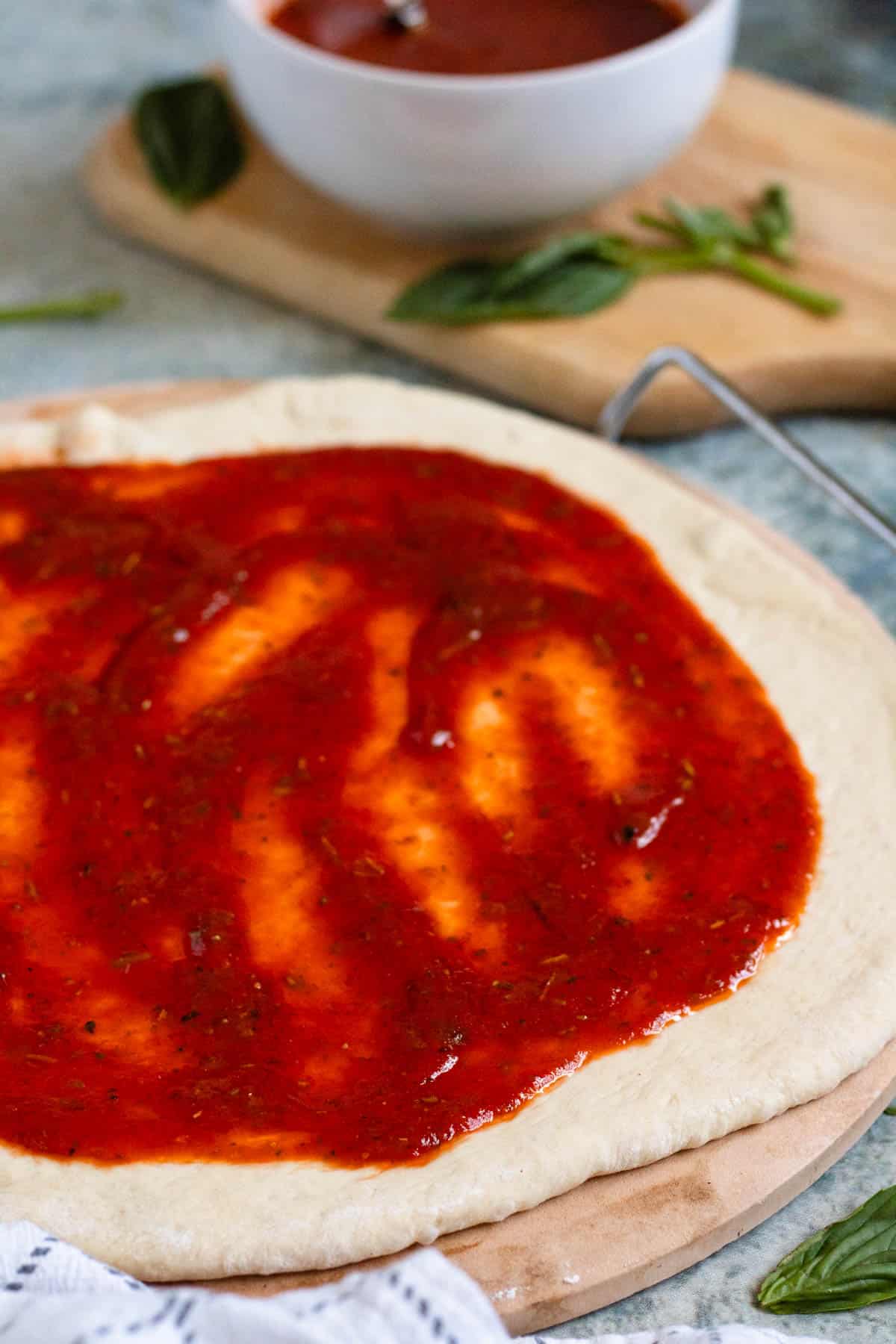 Homemade pizza sauce spread over pizza dough for pizza night.
